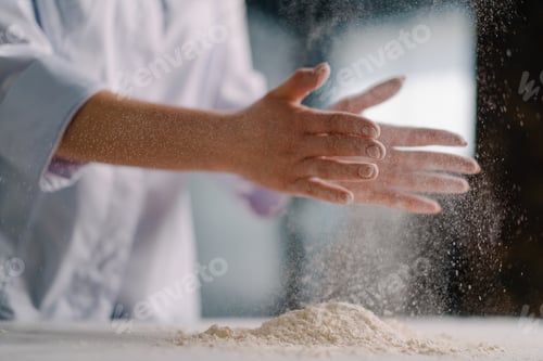 Preview: An experienced chef applies flour to his hands before making bread in a bakery prepares pastries