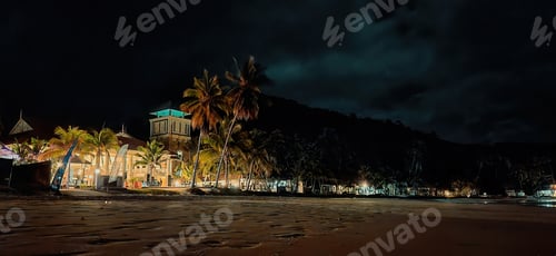 Preview: NIght light at the resort near the beach sand.