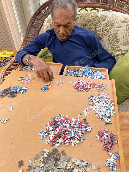 Preview: Senior adult man sitting down starting a new jigsaw puzzle