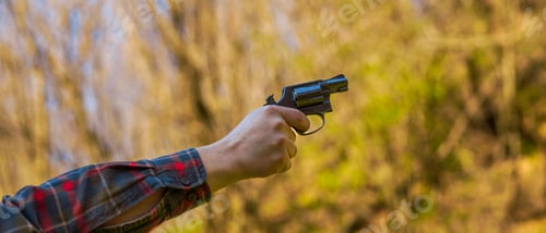 Preview: Unrecognizable man with revolver aiming target on shooting range training outdoors.