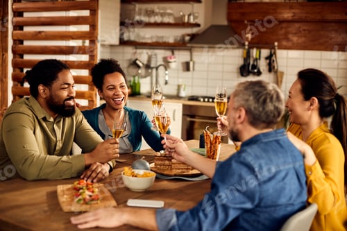 Preview: Cheerful multi-ethnic people toasting with champagne at dining table.