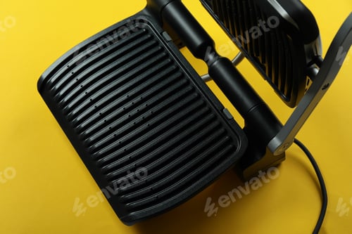 Preview: Modern electric grill on yellow background, close up