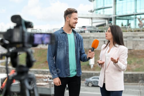 Preview: Young journalist interviewing businesswoman on city street