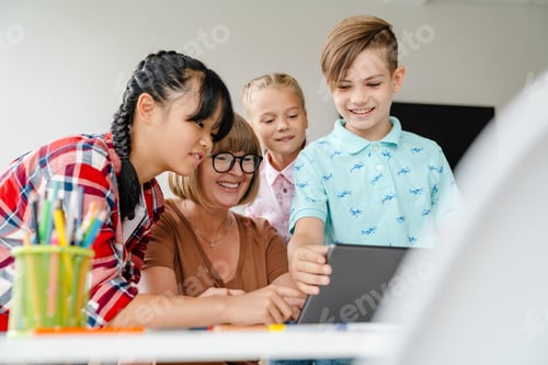 Preview: Multiracial teacher and students using tablet computer in art school