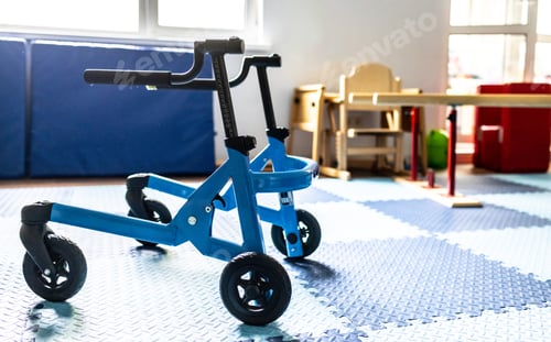 Preview: Blue walker mobility device is positioned in a therapy space designed for children's physical