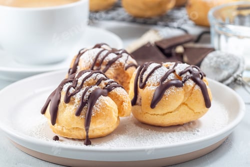 Preview: Profiteroles with whipped cream and chocolate filling, covered with melted chocolate, horizontal
