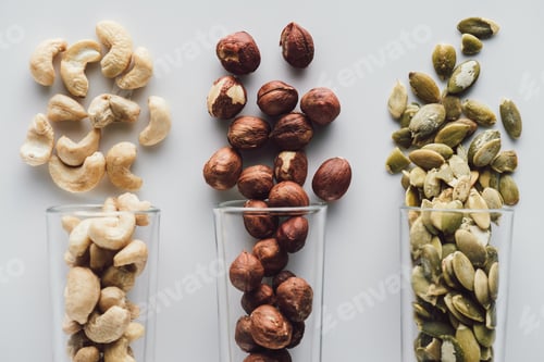 Preview: variety of nuts in glass cups isolated on white background