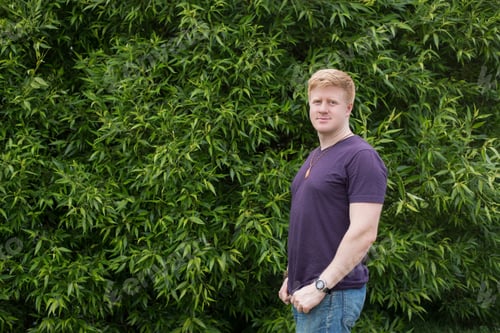 Preview: Man stands by green bush