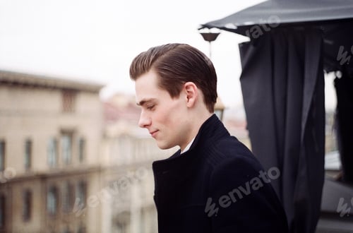 Preview: Young Man Looking Down Outdoors with Brown Hair