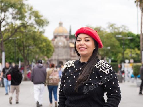 Preview: Outdoor portrait of a smiling woman wearing a red beret and a sweater embellished with pearls