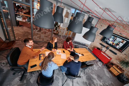 Preview: Top view of a modern startup office, a diverse team of business professionals engage in discussions