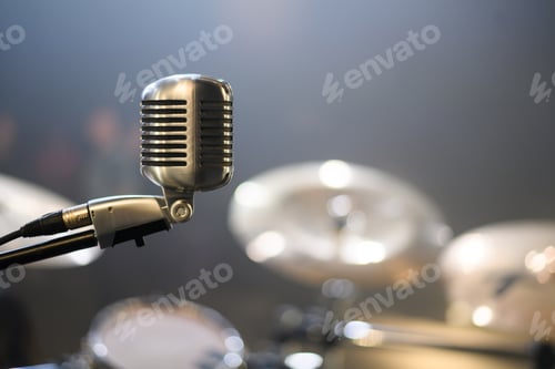 Preview: Microphone standing on a stage with the drum set in the background