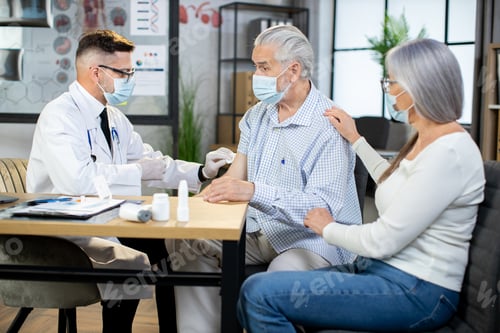 Preview: Senior woman calming husband during vaccination at clinic
