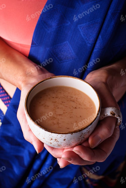 Preview: Woman holding a cup of masala tea