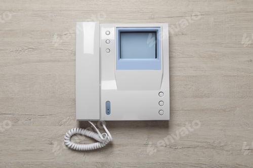 Preview: Modern intercom system with handset on wooden background, top view
