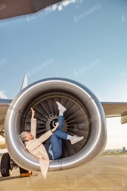 Preview: Cheerful women having fun in airplane engine at airport