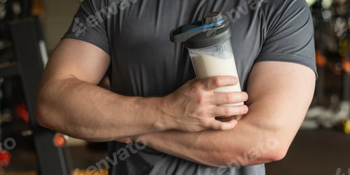 Man Holding Drink in Gym after Workout