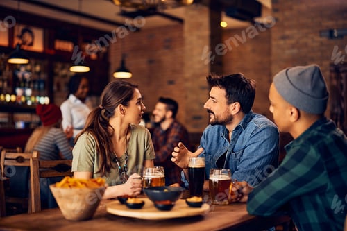 Preview: Young man and his friends communicating while gathering in a pub.