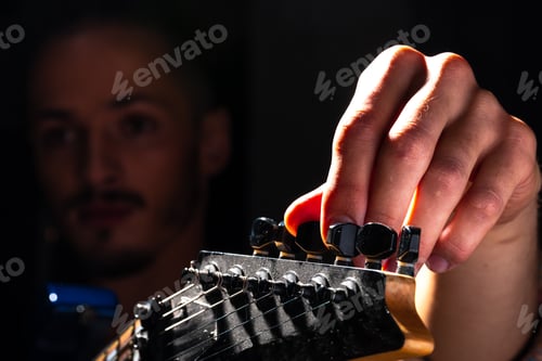Preview: Close up of male hand playing electric guitar in the dark