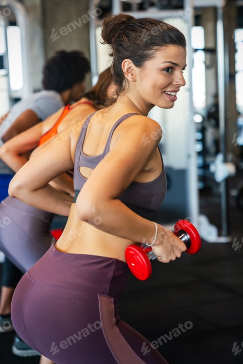 Preview: Portrait of happy fit woman exercise in gym to stay healthy