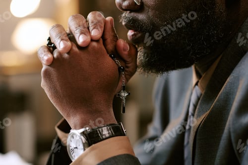 Preview: Black Man Praying with Rosary Beads during Business Meeting