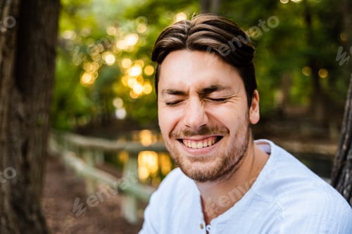 Preview: Male model next to a tree with expression of happiness.