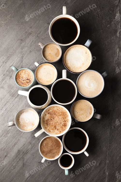 Preview: Many cups of different coffees on slate table, flat lay