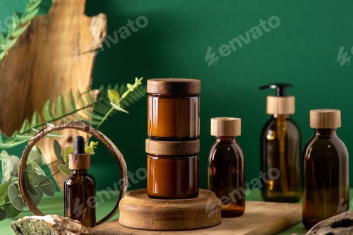 Preview: Glass brown containers for cosmetics with wooden lids. Cream, dropper bottle and lotion. Green