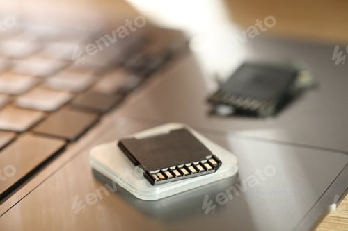 Preview: SD memory cards, holder and laptop on table, closeup