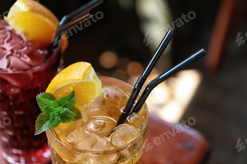 Preview: Glasses of delicious cocktails with ice on blurred background, closeup