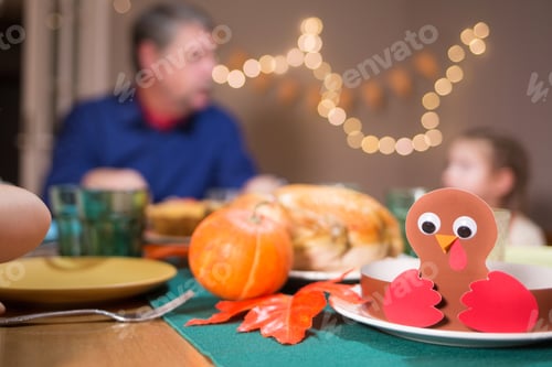 Preview: celebration for thanksgiving. family from different generations is sitting at festive table.