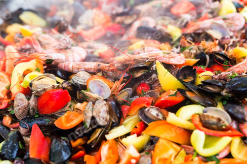 Preview: Street food concept - Gourmet seafood paella with pink marine prawns and mussels on yellow saffron