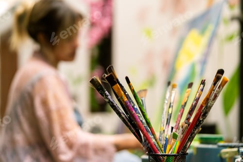 Preview: Paint brushes with artist woman creating art
