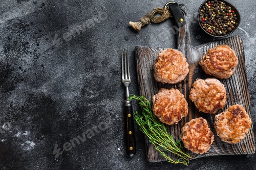 Preview: Roasted cutlets from beef and pork meat. Black background. Top view. Copy space