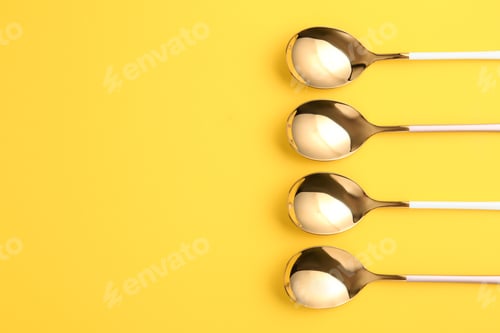 Preview: Flat lay composition with clean tablespoons and space for text on color background