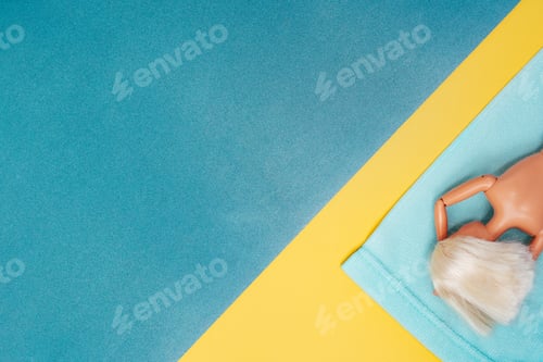 Preview: Nude blonde doll on beach towel. Paper sea and sand.