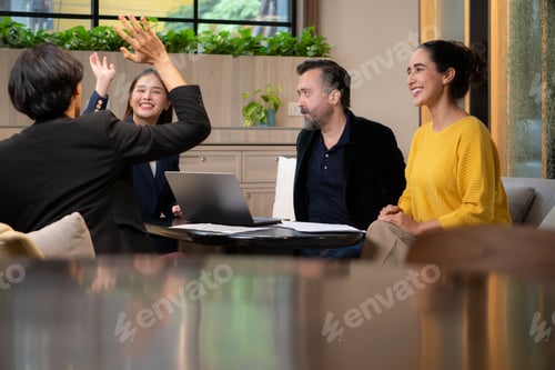Preview: Group of business people discussing business plan at meeting table in office.