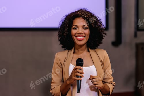 Preview: Portrait of an African woman, holding a microphone in the meeting room.