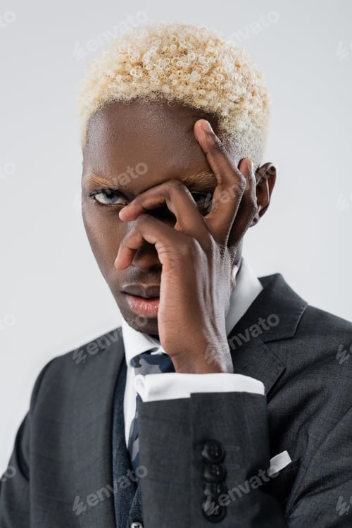 Preview: blonde african american businessman with blue eyes covering face and looking at camera isolated on