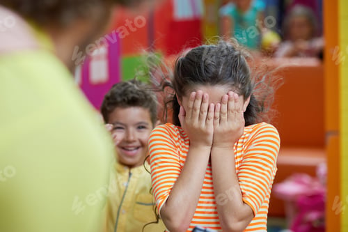 Preview: Kid girl covering her face with both hands.