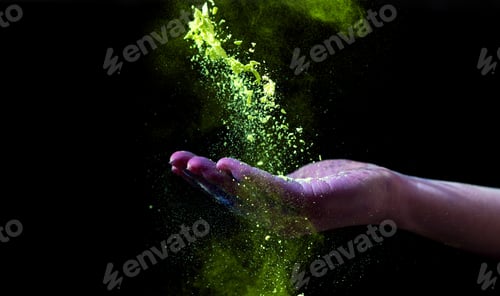 Preview: Yellow holi powder follow down through woman hand on black