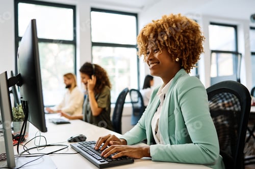 Preview: African woman using computer sitting on a coworking office
