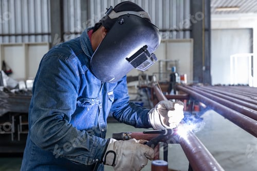 Preview: Welder performing TIG welding on metal pipe