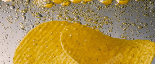 Preview: Deep fried potato chips under golden oil water.