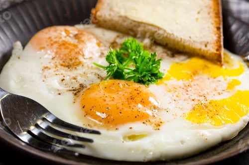 Preview: Fried eggs and bread for breakfast on a gray background.