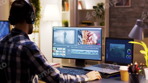 Preview: Film maker pointing at the monitor in home office