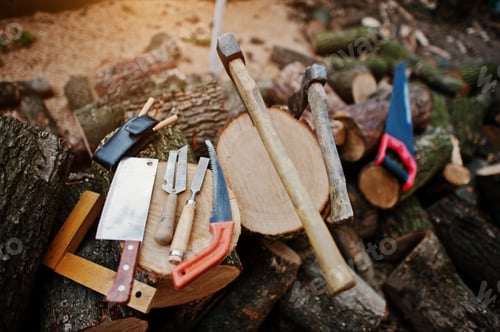 Preview: Two axes in stumps with wood working tools background chopped firewood.