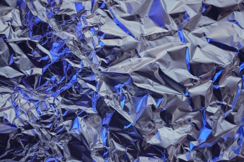 Preview: Wrinkled metallic texture creating an abstract pattern with silver and blue highlights