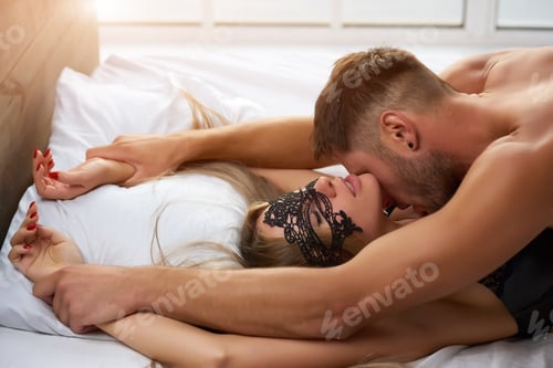 Preview: Man slowly kissing his partner in lace mask.