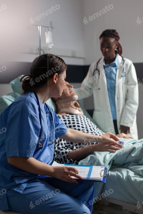 Preview: Medical assistant checking oximeter attached to senior man